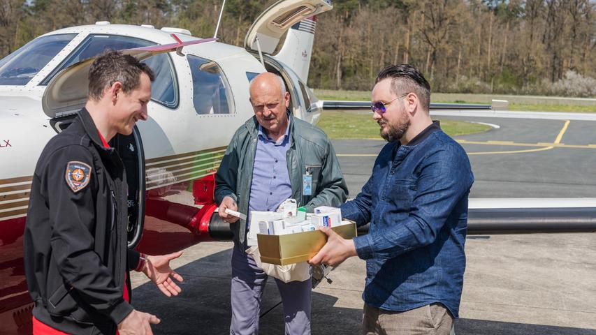 Der Arzt Falk Stirkat und zwei Piloten bringen die Hilfsware an Bord der Cessna. 
