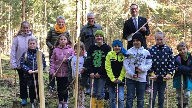 Spaß hatten die Hortkinder bei ihrer Pflanzaktion mit Martin Müller von der Raiffeisenbank und Förster Helmut Lay (hinten v. rechts).