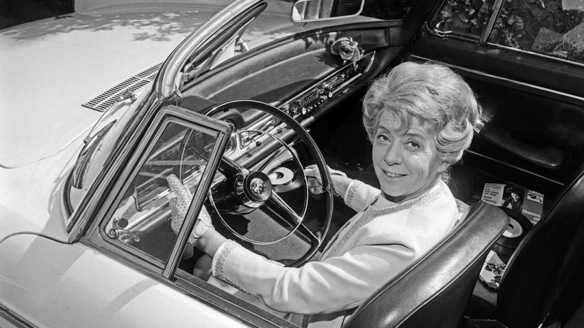 Plattenspieler fürs Auto: Schauspielerin Inge Meysel 1966 bei Dreharbeiten in einem Peugeot 404 Cabrio.
