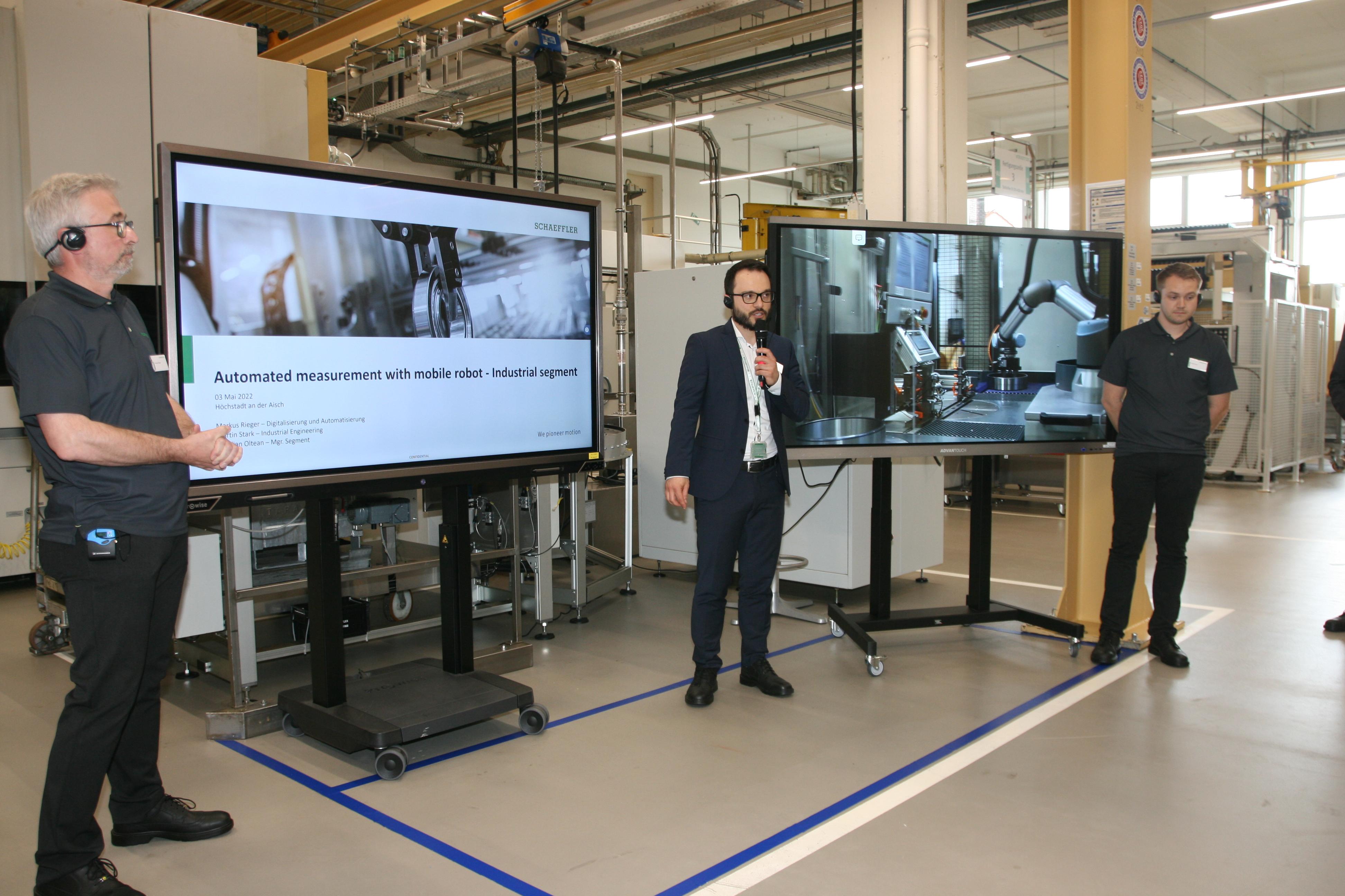 Bei einer Werksführung erklären Mitarbeiter wie die Automatisierung funktioniert.