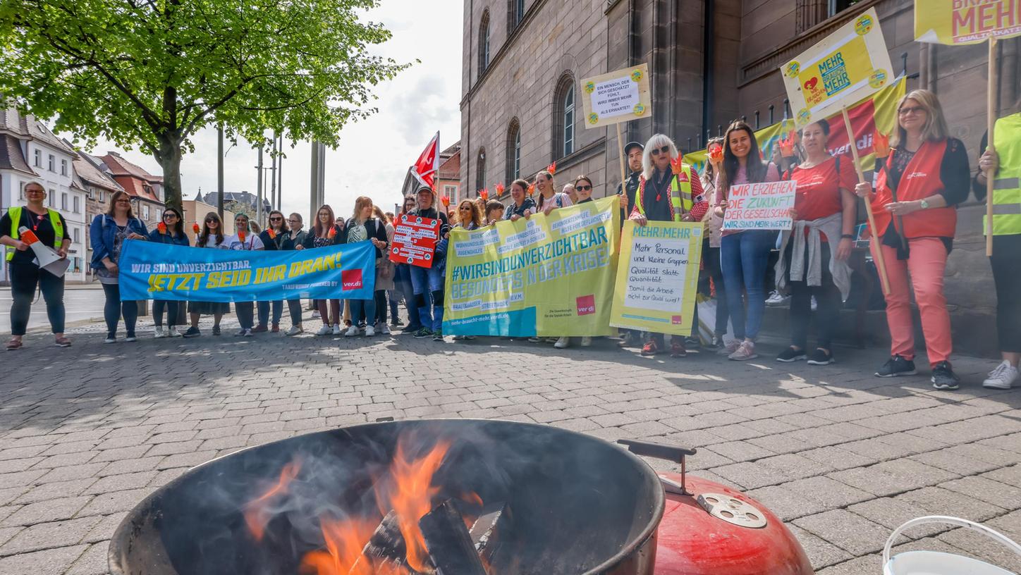 „Die Arbeitgeber spielen mit dem Feuer“, klagt Verdi. Vor dem Fürther Rathaus versammelten sich Kita-Beschäftigte für die Aktion „Fünf nach Zwölf“ – mit Feuertonne.