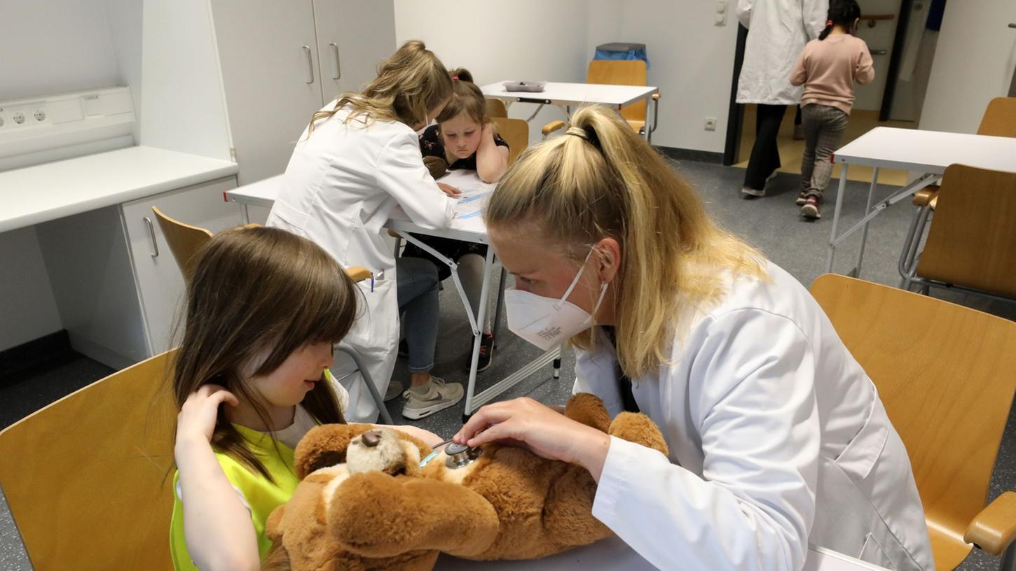 Nach der Wiedereröffnung des Teddybärkrankenhauses an der Universitätsmedizin empfängt Anna Rautmann, Medizinstudentin, den Teddy einer kleinen Besucherin.