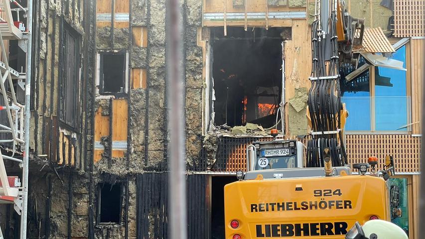 Nun hilft ein Bagger eines privaten Abrissunternehmens der Feuerwehr bei den Löscharbeiten.