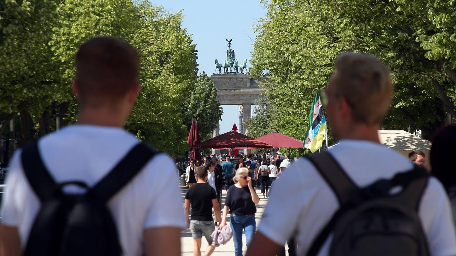 Touristen laufen auf der Straße "Unter den Linden" im Berlin. Die Tourismus-Branche verzeichnet wieder mehr Gäste und Übernachtungen.