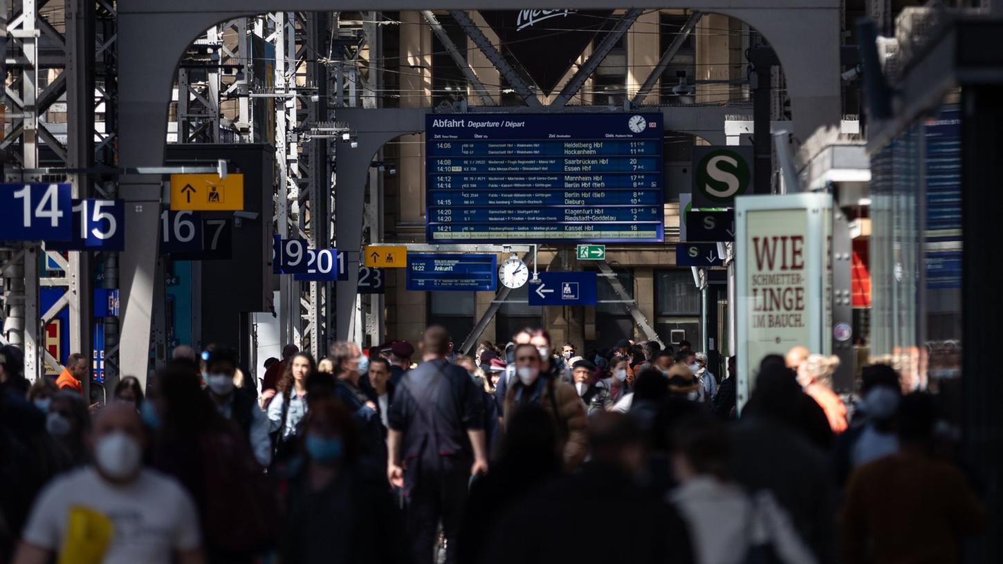 Reisende gehen durch die Bahnhofshalle in Frankfurt/Main. Die Debatte um die Maskenpflicht in öffentlichen Transportmitteln geht weiter. Reisende gehen durch die Bahnhofshalle in Frankfurt/Main. Die Debatte um die Maskenpflicht in öffentlichen Transportmitteln geht weiter.