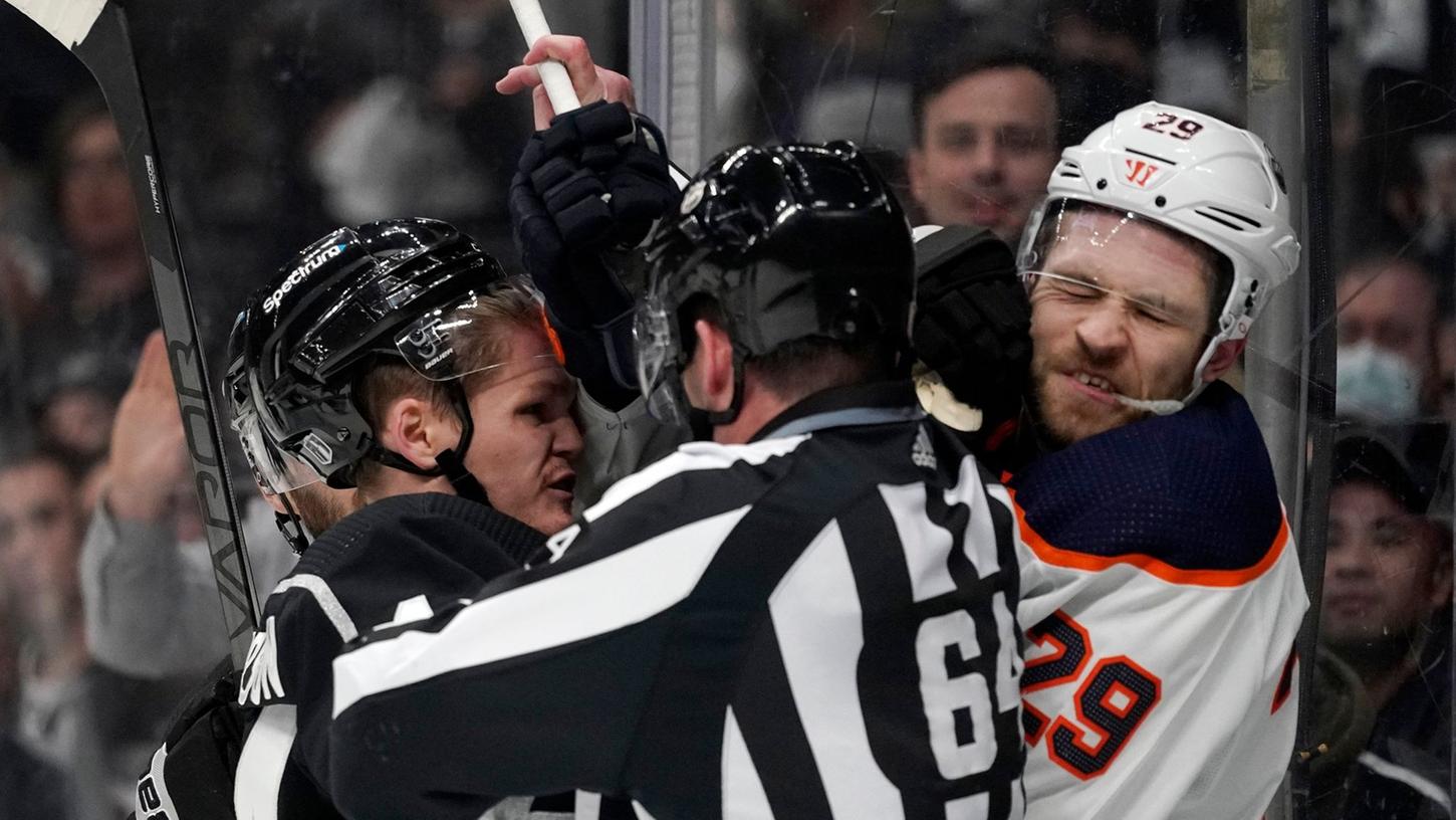 Mikey Anderson von den Los Angeles Kings (l) im Clinch mit Leon Draisaitl - der Schiedsrichter geht dazwischen. Mikey Anderson von den Los Angeles Kings (l) im Clinch mit Leon Draisaitl - der Schiedsrichter geht dazwischen.
