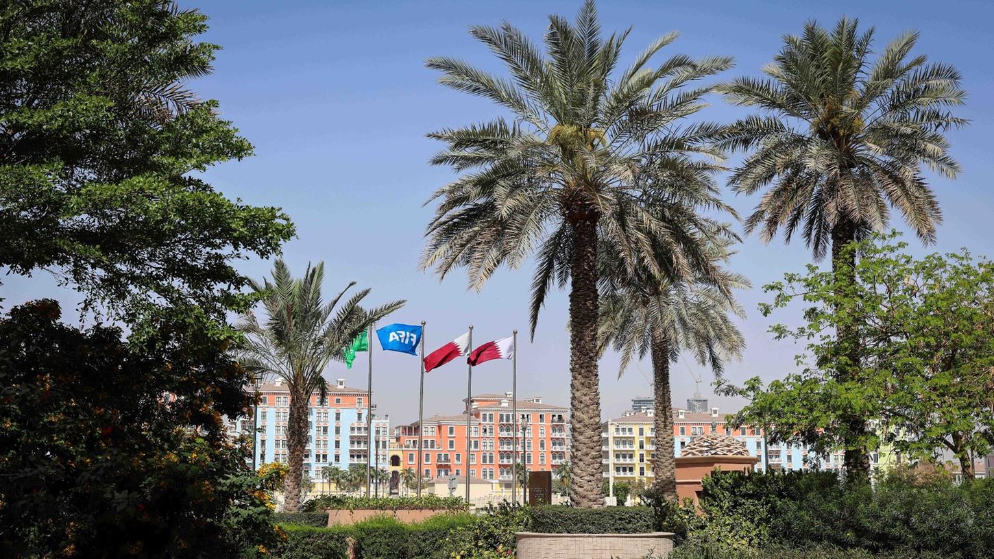 Die Flaggen Katars und der FIFA wehen vor einer Hotelanlage in Doha. Die Flaggen Katars und der FIFA wehen vor einer Hotelanlage in Doha.
