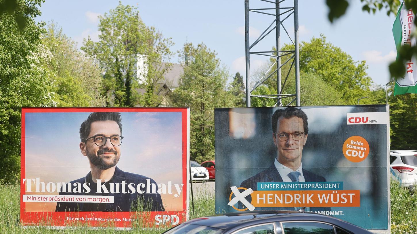Wahlplakate mit Portraits von Ministerpräsident Hendrik Wüst (r) und Herausforderer Thomas Kutschaty von der SPD.
