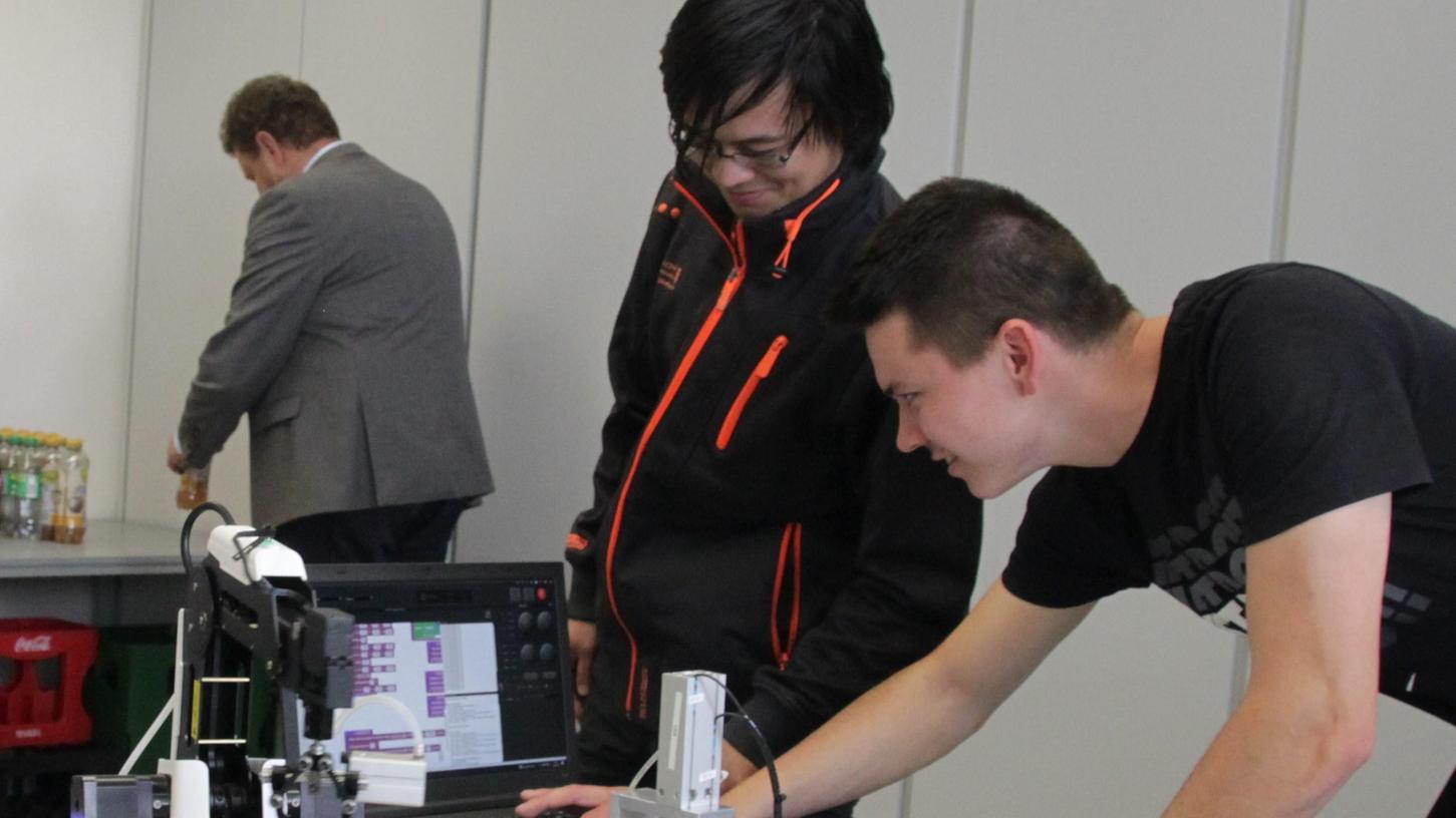 Per Computer wird der Roboterarm gesteuert, so können Russlan Panzer(links, Frankenschotter Dietfurt) und Aaron Tremel (rechts, Maschinen Wicke, Ellingen) den LKW auf das Lieferband transportieren. Per Computer wird der Roboterarm gesteuert, so können Russlan Panzer(links, Frankenschotter Dietfurt) und Aaron Tremel (rechts, Maschinen Wicke, Ellingen) den LKW auf das Lieferband transportieren.