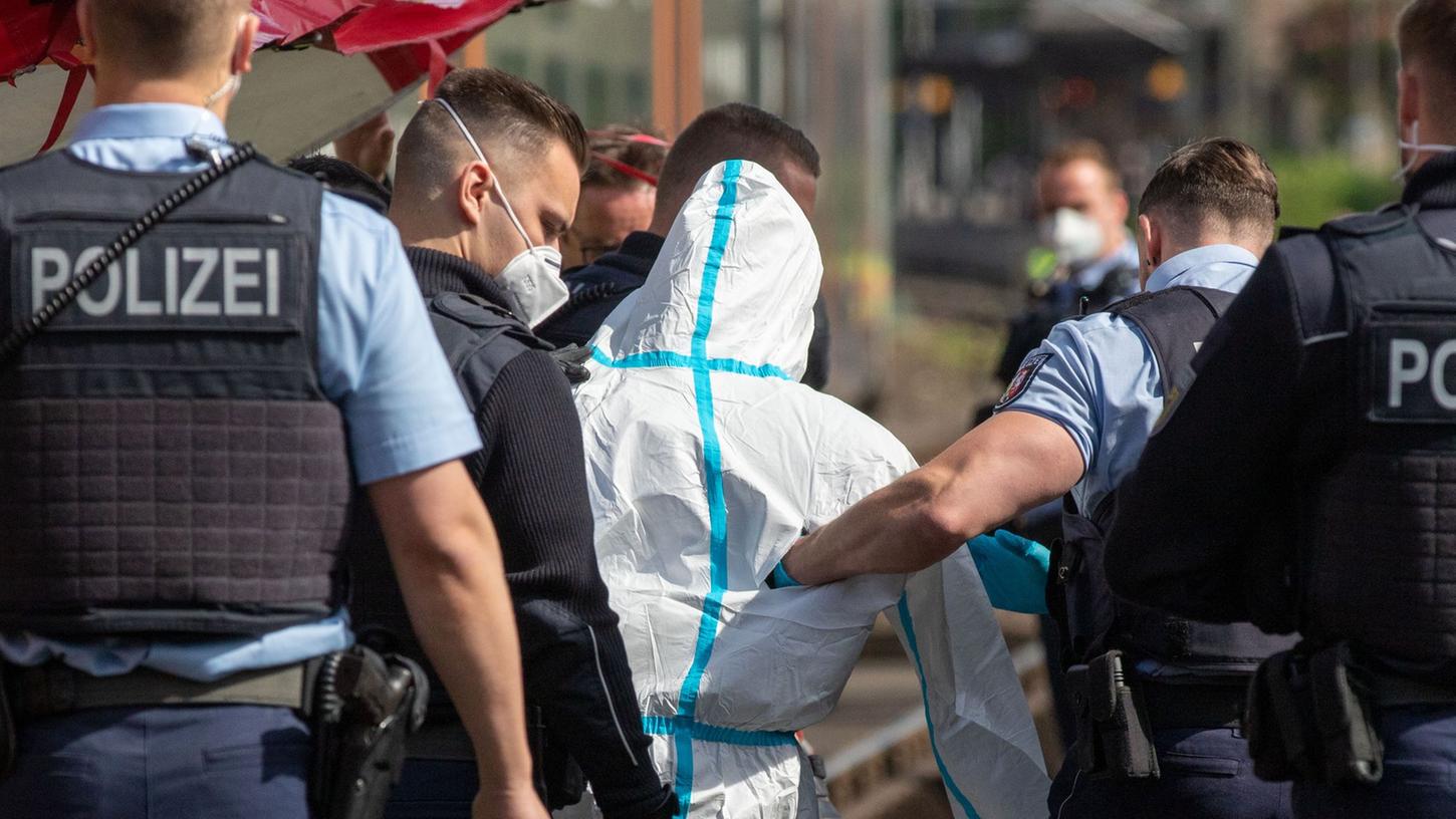 Polizisten führen den mutmaßlichen Täter ab. Der Mann soll in einer Regionalbahn mit einem Messer auf Reisende eingestochen haben. Polizisten führen den mutmaßlichen Täter ab. Der Mann soll in einer Regionalbahn mit einem Messer auf Reisende eingestochen haben.