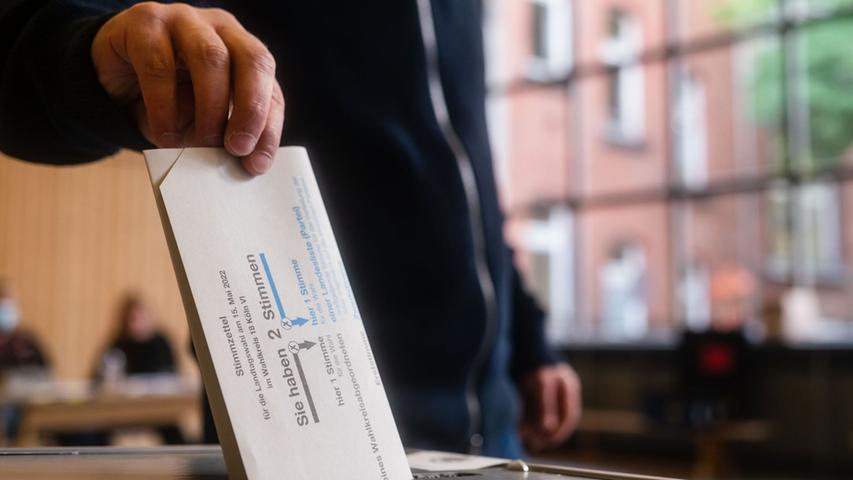 Ein Mann wirft in Köln seinen Stimmzettel in die Wahlurne.
