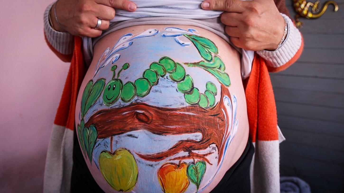 Ritual für Schwangere: Hobbymalerin verziert Babybäuche