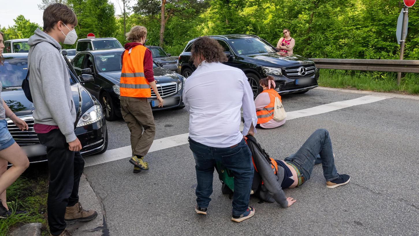 Ein aufgebrachter Autofahrer zerrt einen von mehreren Klima-Aktivisten der Gruppe "Letzte Generation" von der Straße. Ein aufgebrachter Autofahrer zerrt einen von mehreren Klima-Aktivisten der Gruppe "Letzte Generation" von der Straße.