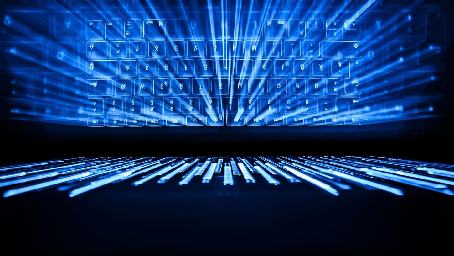 Die beleuchtete Tastatur eines Laptops spiegelt sich im Bildschirm. Die beleuchtete Tastatur eines Laptops spiegelt sich im Bildschirm.