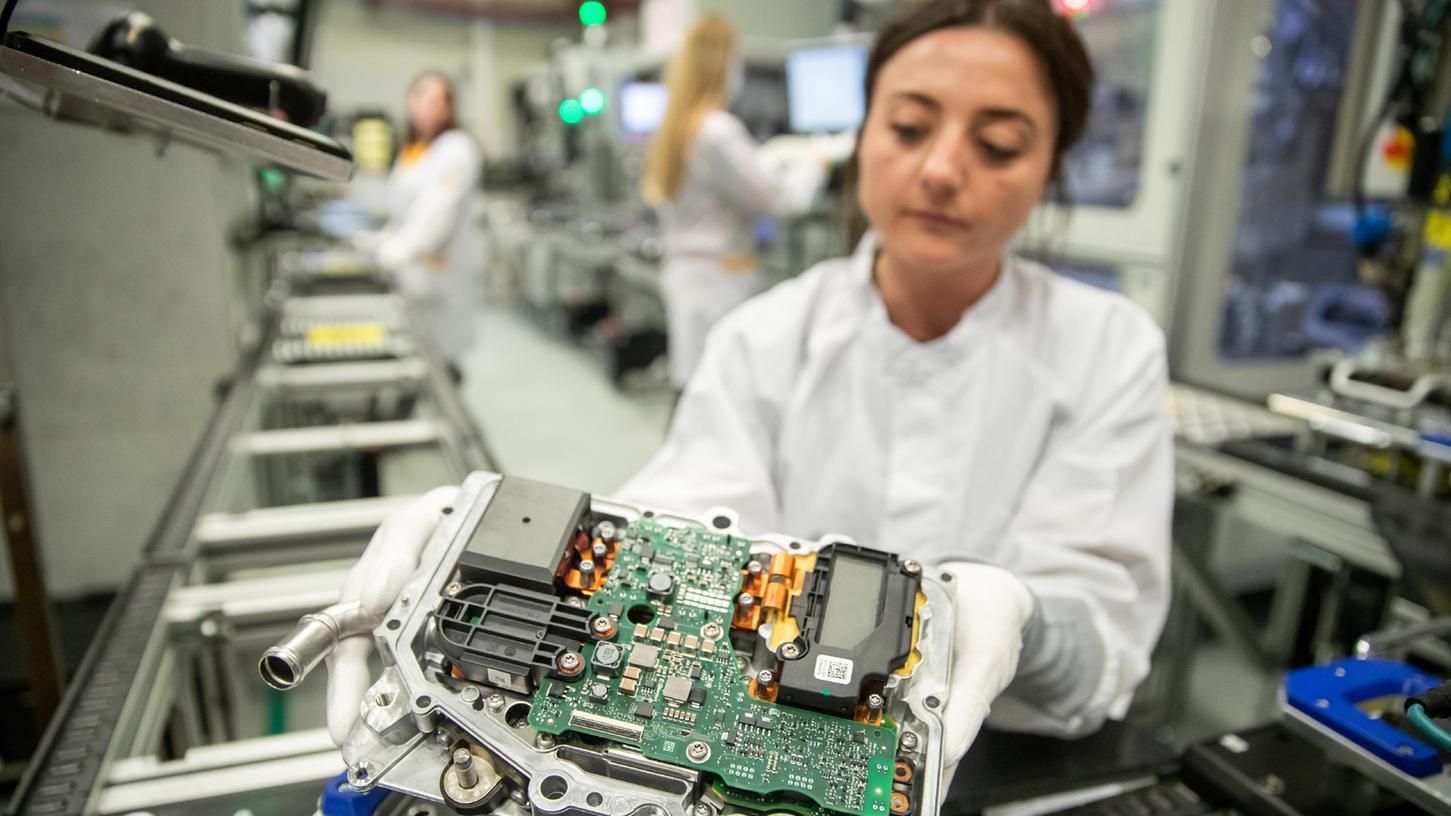 Eine Mitarbeiterin bei Continental hält in der Produktion der Leistungselektronik für Elektrofahrzeuge eine sogenannte DC/DC-Halbschale in der Hand.
Eine Mitarbeiterin bei Continental hält in der Produktion der Leistungselektronik für Elektrofahrzeuge eine sogenannte DC/DC-Halbschale in der Hand.
