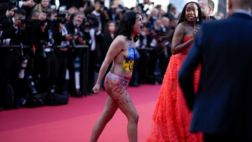 Eine Demonstrantin nutzte die Aufmerksamkeit der Fotografen beim Filmfestival in Cannes, um gegen den Krieg Russlands in ihrer Heimat zu protestieren. Sie trug eine Körperbemalung mit der Aufschrift "Stop Raping Us" (Hört auf uns zu vergewaltigen) in den Farben der ukrainischen Flagge.