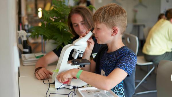 Auch Leon (9) sah sich die unterschiedlichsten Dinge unterm Mikroskop an: Insekten, Müsli, Salz... Was war am tollsten? "Alles war cool!", sagt er strahlend. Student Niklas Hartlieb zeigte ihm, was man im Detail alles bestaunen kann.