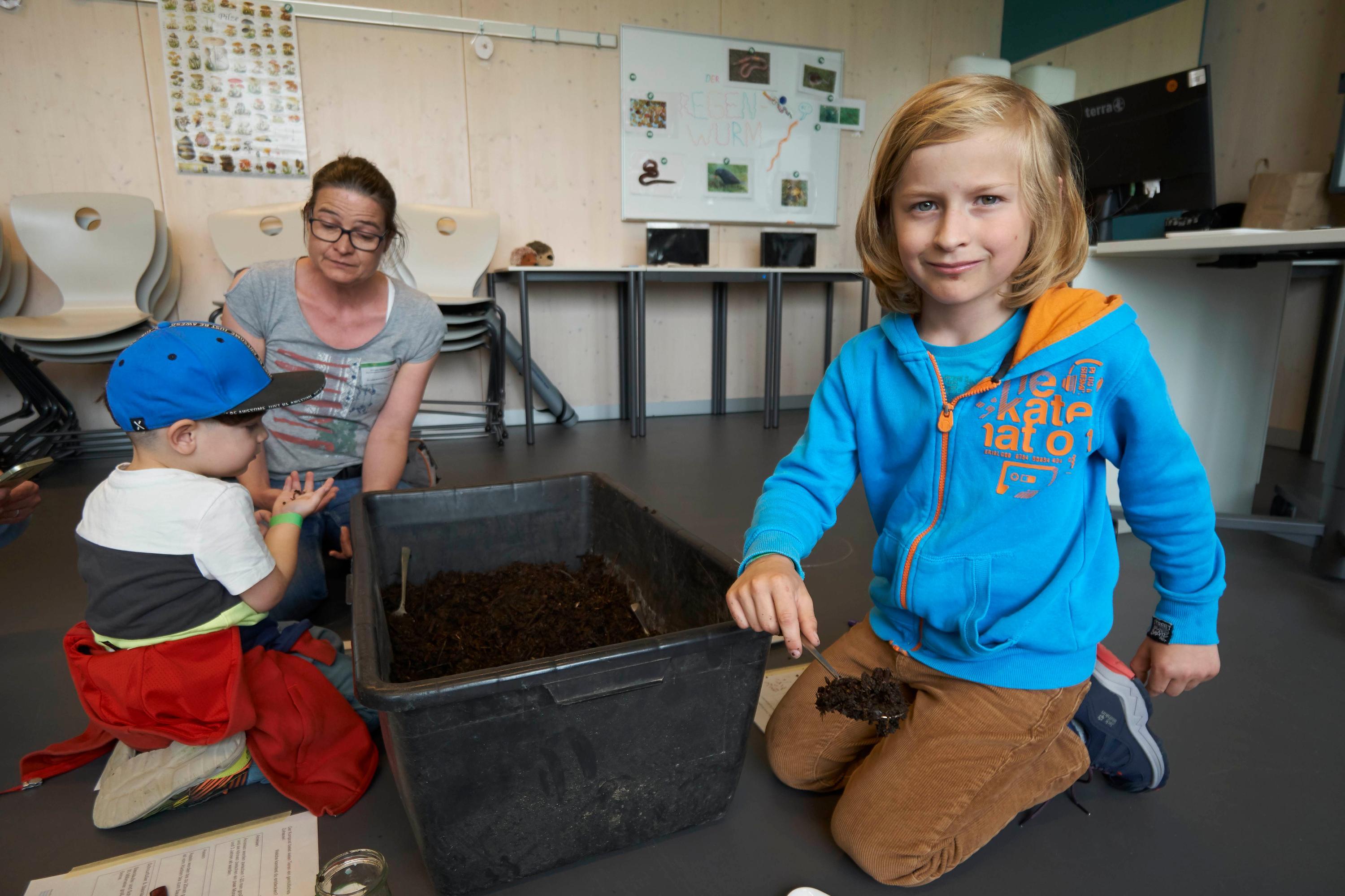 Was steckt eigentlich in unserem Kompost? Vorsichtig konnten die Kinder in Kompostboxen wühlen. Paul schnappte sich einen Löffel und ging auf Entdeckungstour...