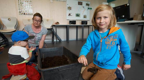 Was steckt eigentlich in unserem Kompost? Vorsichtig konnten die Kinder in Kompostboxen wühlen. Paul schnappte sich einen Löffel und ging auf Entdeckungstour...