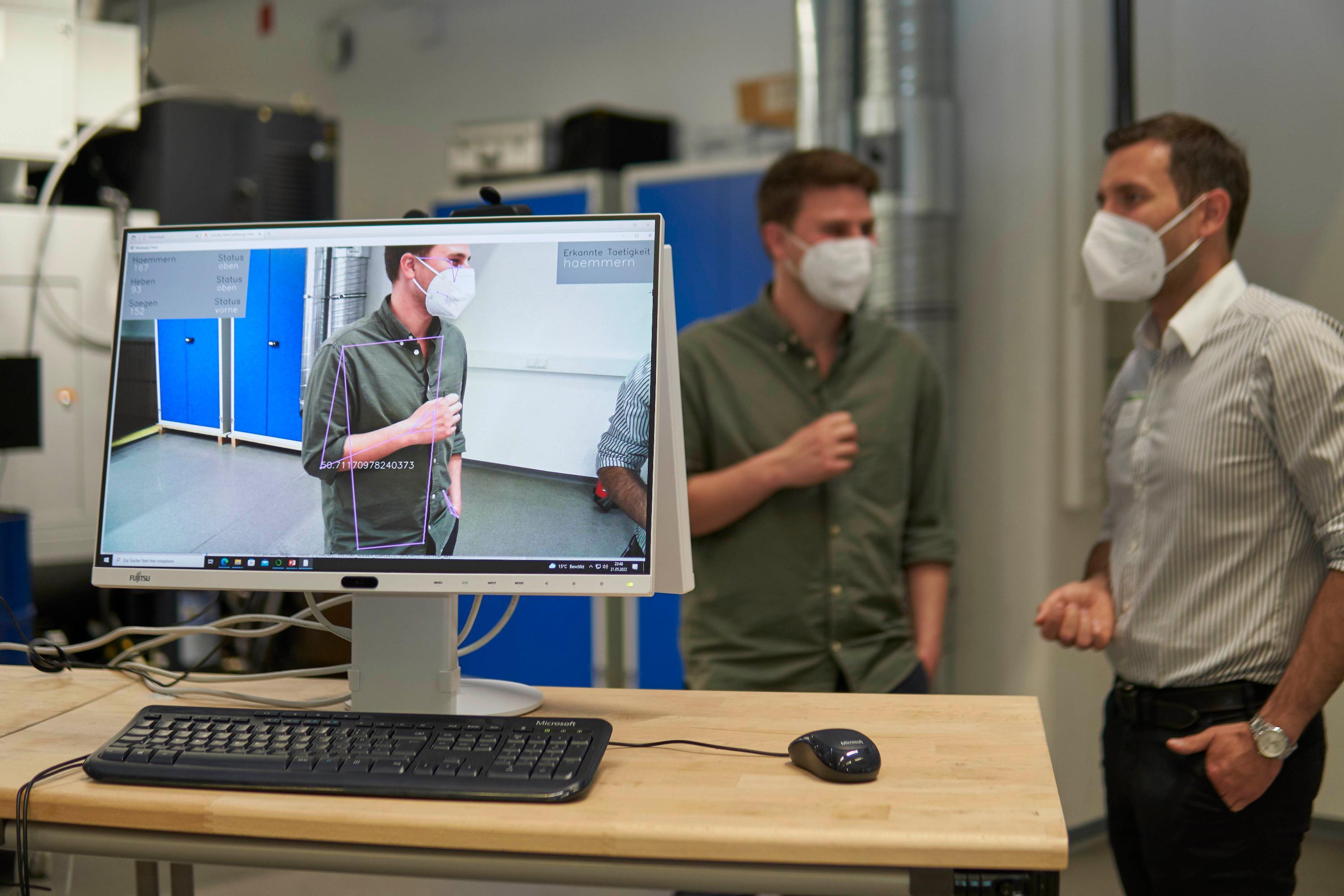 Neue Techniken können dabei helfen, Arbeits- und Fertigungsprozesse präziser auszuführen und Fehler zu verringern. Der Lehrstuhl für Ressourcen- und Energieeffiziente Produktionsmaschinen (REP) der FAU zeigte anschaulich, welches Potenzial maschinelle Lernverfahren zur Lokalisierung von Objekten bzw. Menschen im Bild sowie die Erkennung von manuellen Handlungen (zum Beispiel Hämmern, Sägen, Heben) haben kann. Im Bild: Mitarbeiter Matthias Mühlbauer (rechts) im Gespräch mit seinem Kollegen Heiko Wehner.