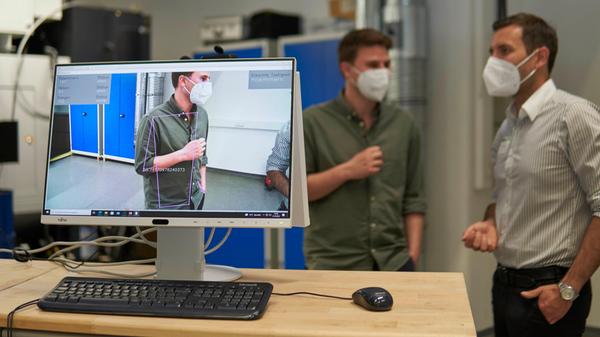 Neue Techniken können dabei helfen, Arbeits- und Fertigungsprozesse präziser auszuführen und Fehler zu verringern. Der Lehrstuhl für Ressourcen- und Energieeffiziente Produktionsmaschinen (REP) der FAU zeigte anschaulich, welches Potenzial maschinelle Lernverfahren zur Lokalisierung von Objekten bzw. Menschen im Bild sowie die Erkennung von manuellen Handlungen (zum Beispiel Hämmern, Sägen, Heben) haben kann. Im Bild: Mitarbeiter Matthias Mühlbauer (rechts) im Gespräch mit seinem Kollegen Heiko Wehner.