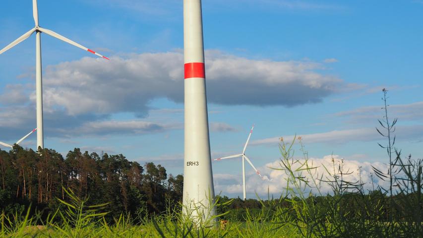 Es ist ein kurioser Fall mit einer plötzlichen Wende: Da will eine Gemeinde unter einem ihrer Windräder einen Solarpark bauen - eine geniale Idee, weil das Areal weit weg ist von den nächsten Häusern und die Photovoltaikanlage hier niemanden stört. Allein, sie darf nicht, weil es dem regionalen Planungsverband nicht gefällt - jedenfalls am Anfang.   Dabei ist Lonnerstadt vorbildlich im Kreis Erlangen-Höchstadt. Fünf Windräder auf dem Gemeindegrund, eine Biogasanlage und diverse Solardächer liefern so viel Strom, dass Lonnerstadt nicht nur seinen Bedarf deckt, sondern Strom exportieren kann. Und die Bevölkerung zieht mit. Mit der Doppelnutzung von Wind und Sonne könnte man ein Maximum an erneuerbaren Energien auf einer kompakten Fläche erzeugen.  Trotzdem signalisiert die Regierung zunächst, dass „kein Verhandlungsspielraum“ bestehe. Das Gelände für den Solarpark ist nämlich als Vorranggebiet für Windkraft ausgewiesen.  Doch dann kommt der bayerische Wirtschaftsminister Hubert Aiwanger persönlich und verkündet vor Ort die Wende. Das Projekt im Aischgrund könne sogar Modell für den gesamten Freistaat werden. Plötzlich klingt alles ganz einfach: „Die Gemeinde muss die Bauleitplanung machen, dann läuft das Ding“, sagte der Ressortchef beim Termin unter dem Windrad ERH 3 zwischen Lonnerstadt und Ailsbach.
