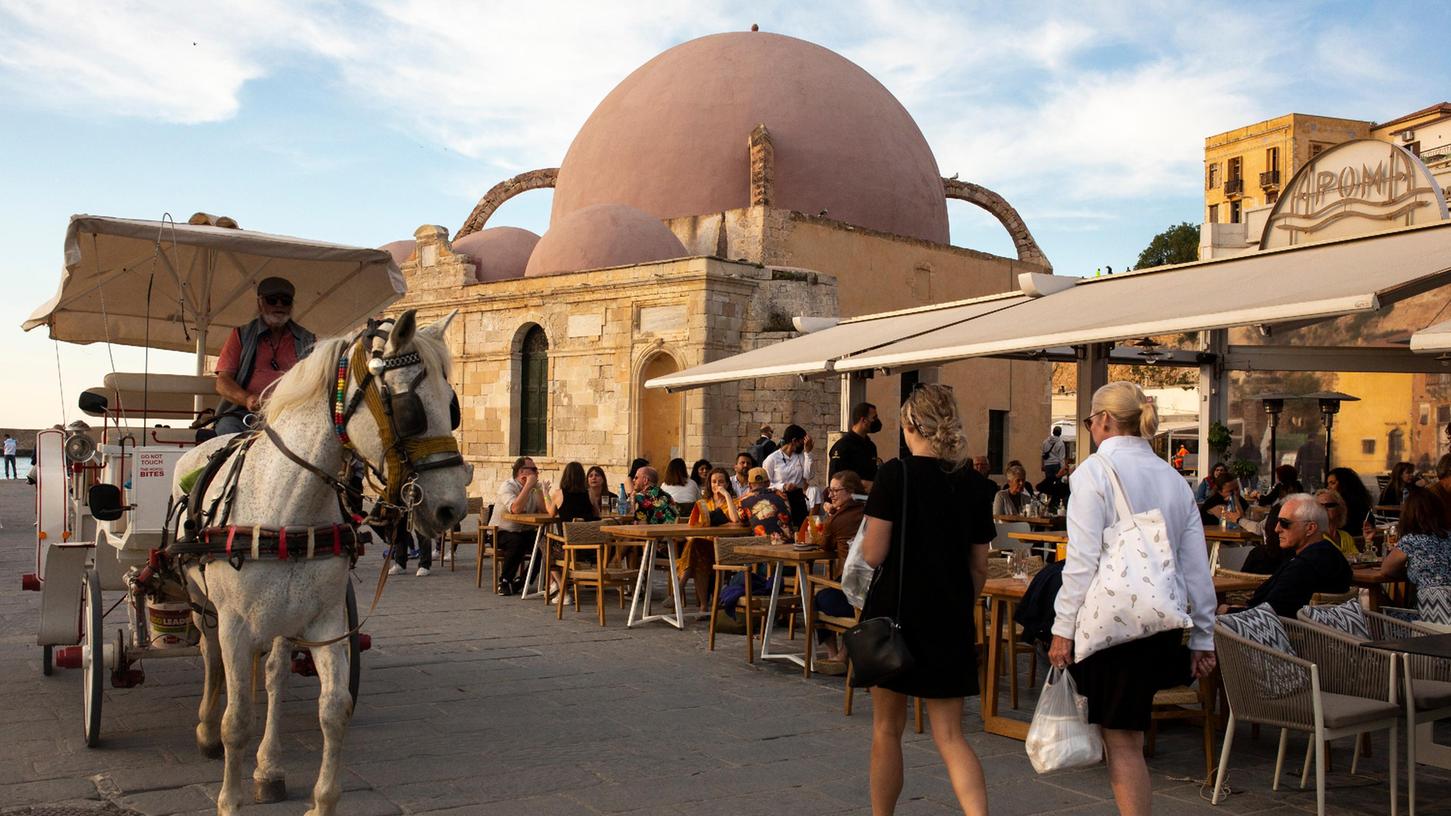 Touristen spazieren am alten Hafen von Chania auf der Insel Kreta. 