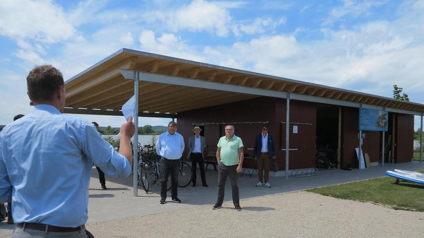 Daniel Burmann (links) vom Zweckverband Altmühlsee erläuterte den Bezirksräten die neue Verleihstation für Fahrräder und Boote direkt am Muhrer Ufer. Für das Bauprojekt floss auch Geld aus der Bezirkskasse.
