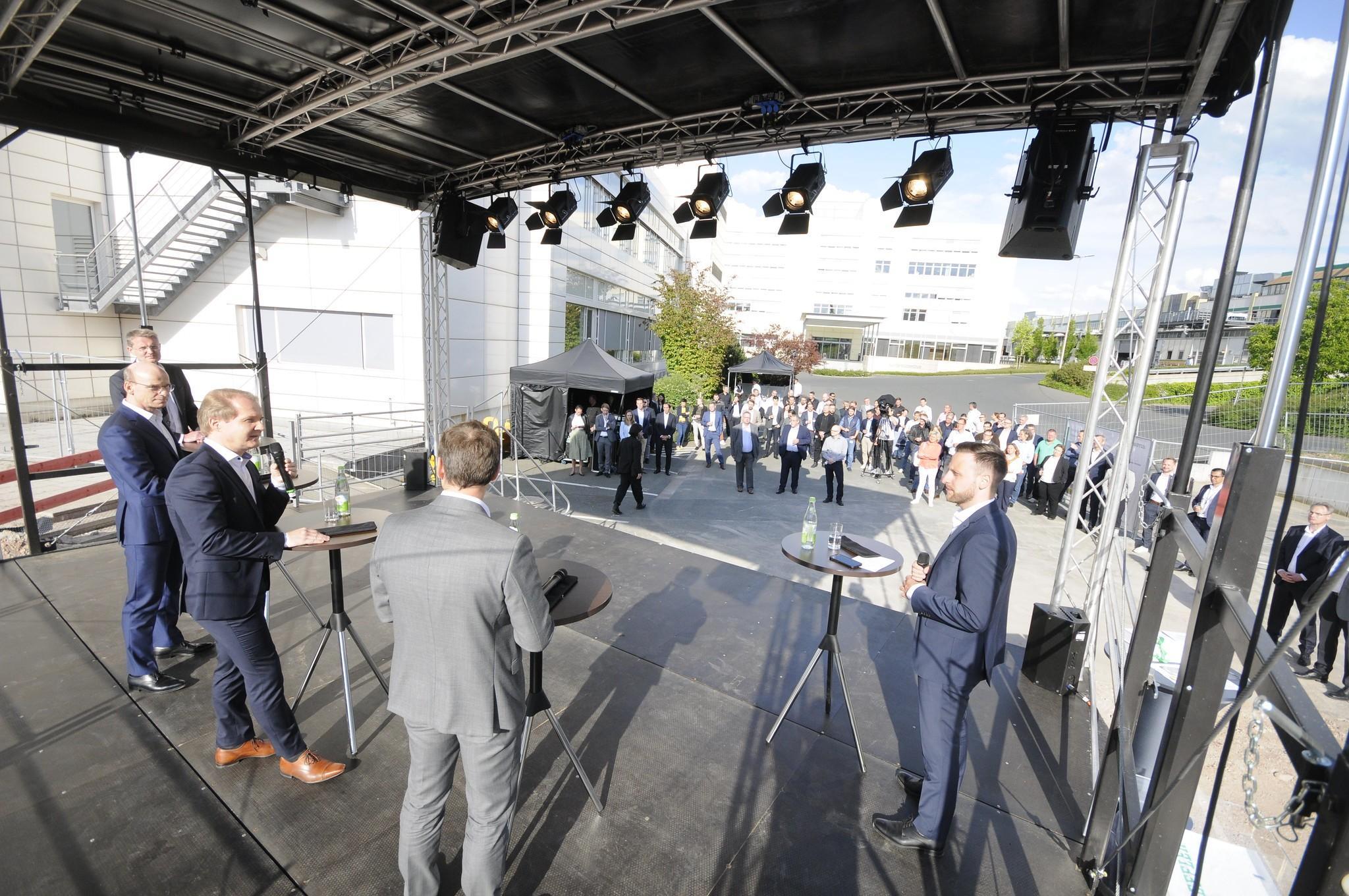 Der Zeremonie wohnen Dutzende von Mitarbeitern bei. 