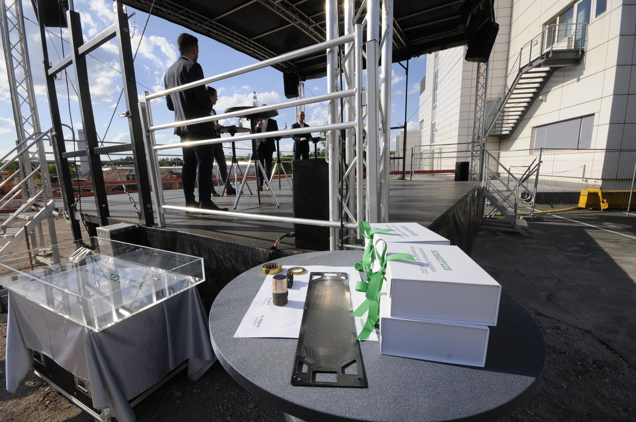 Auf der Bühne wird noch gesprochen, die "Zugaben" für den Grundstein (aktuelle Schaeffler-Bauteile) liegen schon bereit.