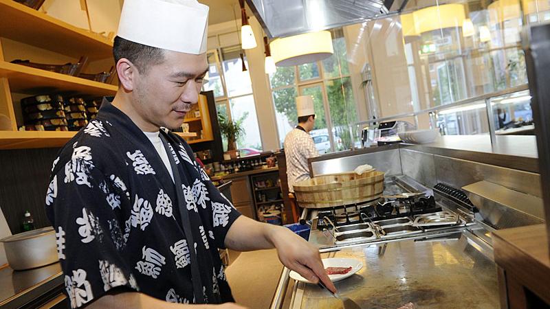 Chefkoch Guomin Zou bereitet am heißen „teppan“-Stahl Muscheln zu, die sich ein Buffetgast ausgesucht hat.
