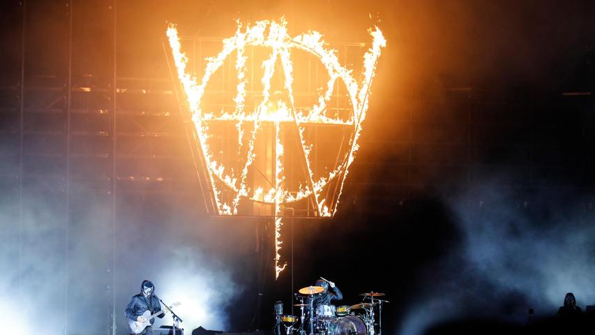 Muse starteten maskiert und brannten ihr umgedrehtes Initial über der Bühne ab.
