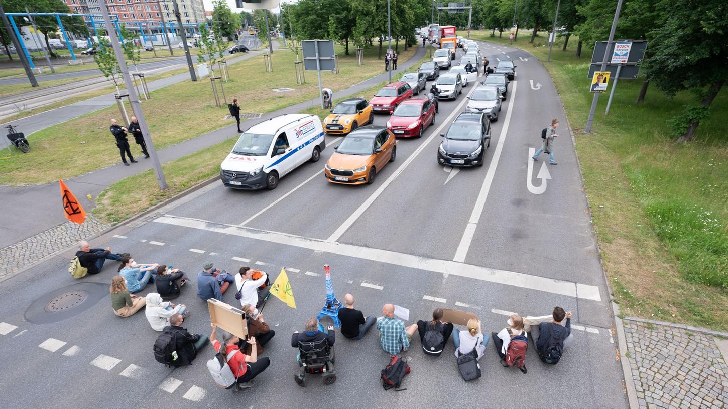 Aktivisten klebten sich an der Straße fest. (Symbolbild)