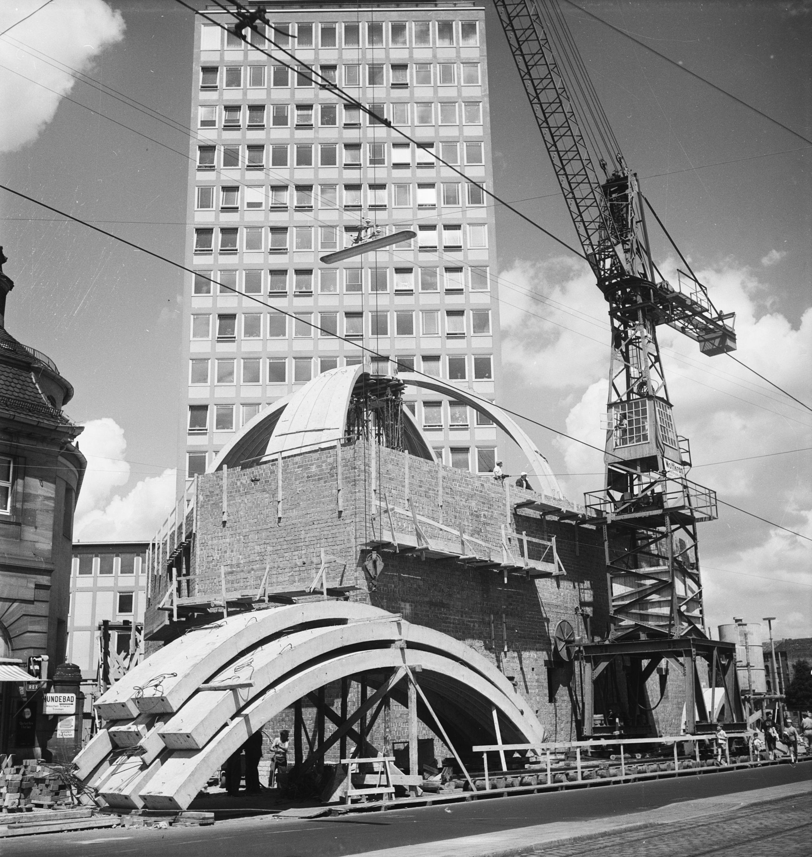 Beton ist biegsam: Die Fertigteile für die Kuppel des Planetariums am Plärrer wurden 1960 mit Hilfe eines Krans zusammengesetzt. Im Hintergrund ist das bekannte, denkmalgeschützte Hochhaus, das Architekt Wilhelm Schlegtendal entworfen hat.