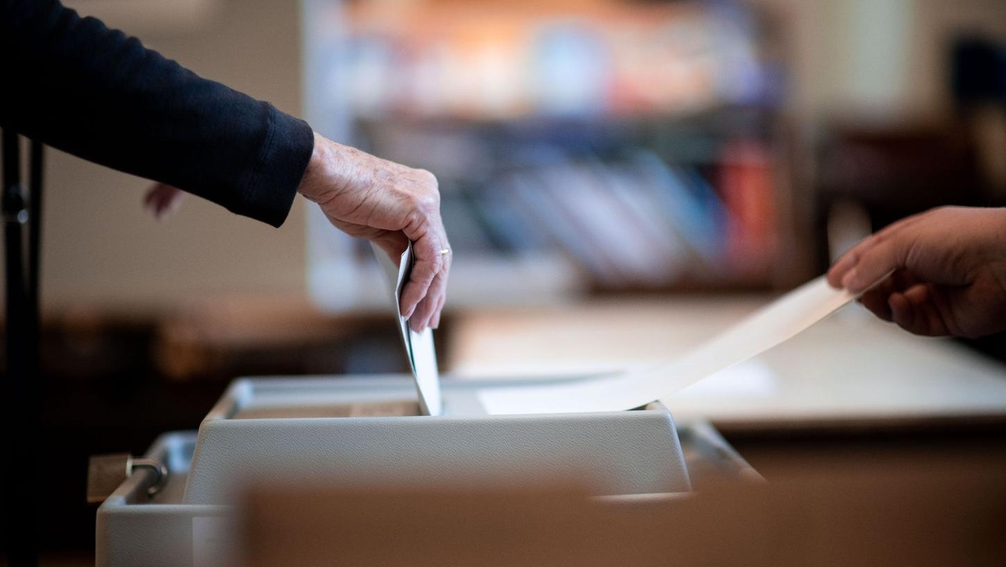 Eine Frau wirft ihren Stimmzettel in ein Wahlurne (Symbolbild). Am Sonntag, 30. April, wird im Landkreis Roth ein neuer Landrat gewählt.
