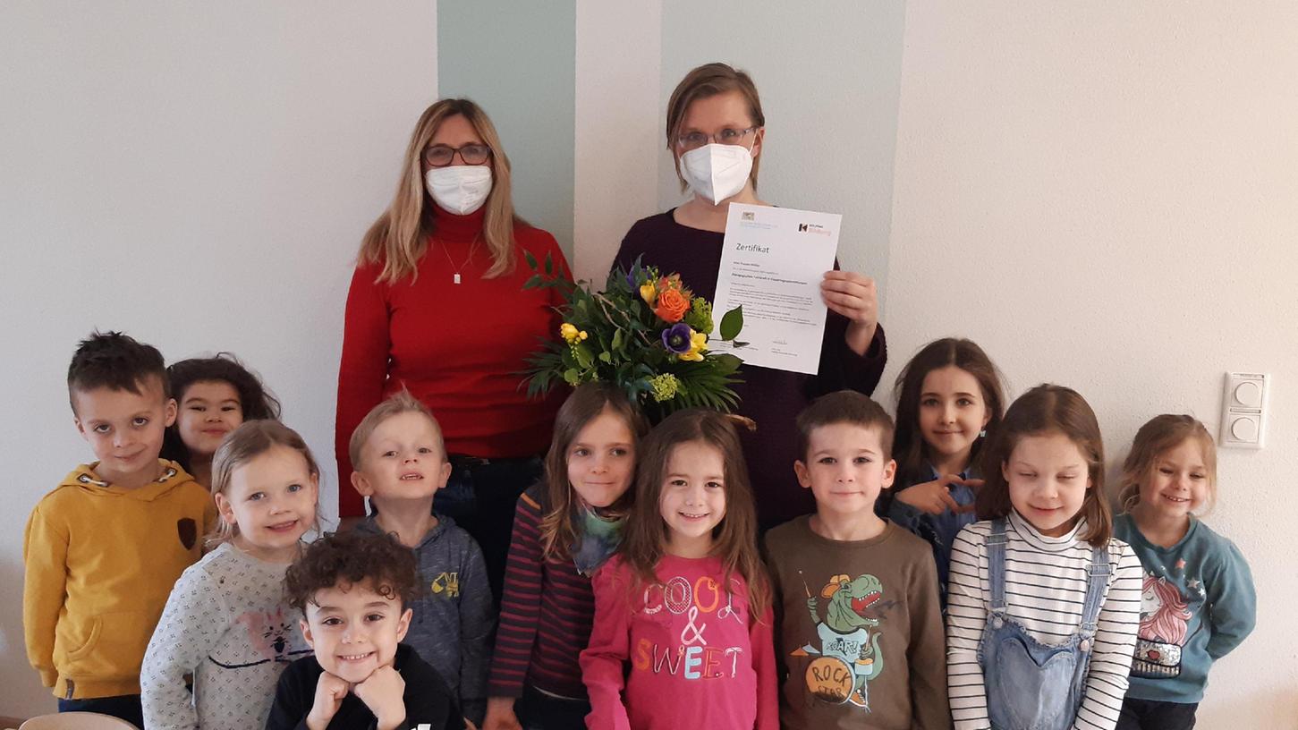 Einrichtungsleitung Conny Frickinger (links) mit Absolventin Yvonne Müller, die nun pädagogische Fachkraft für Kindertageseinrichtungen ist, sowie einige der Kinder, die in der Einrichtung betreut werden.
Einrichtungsleitung Conny Frickinger (links) mit Absolventin Yvonne Müller, die nun pädagogische Fachkraft für Kindertageseinrichtungen ist, sowie einige der Kinder, die in der Einrichtung betreut werden.