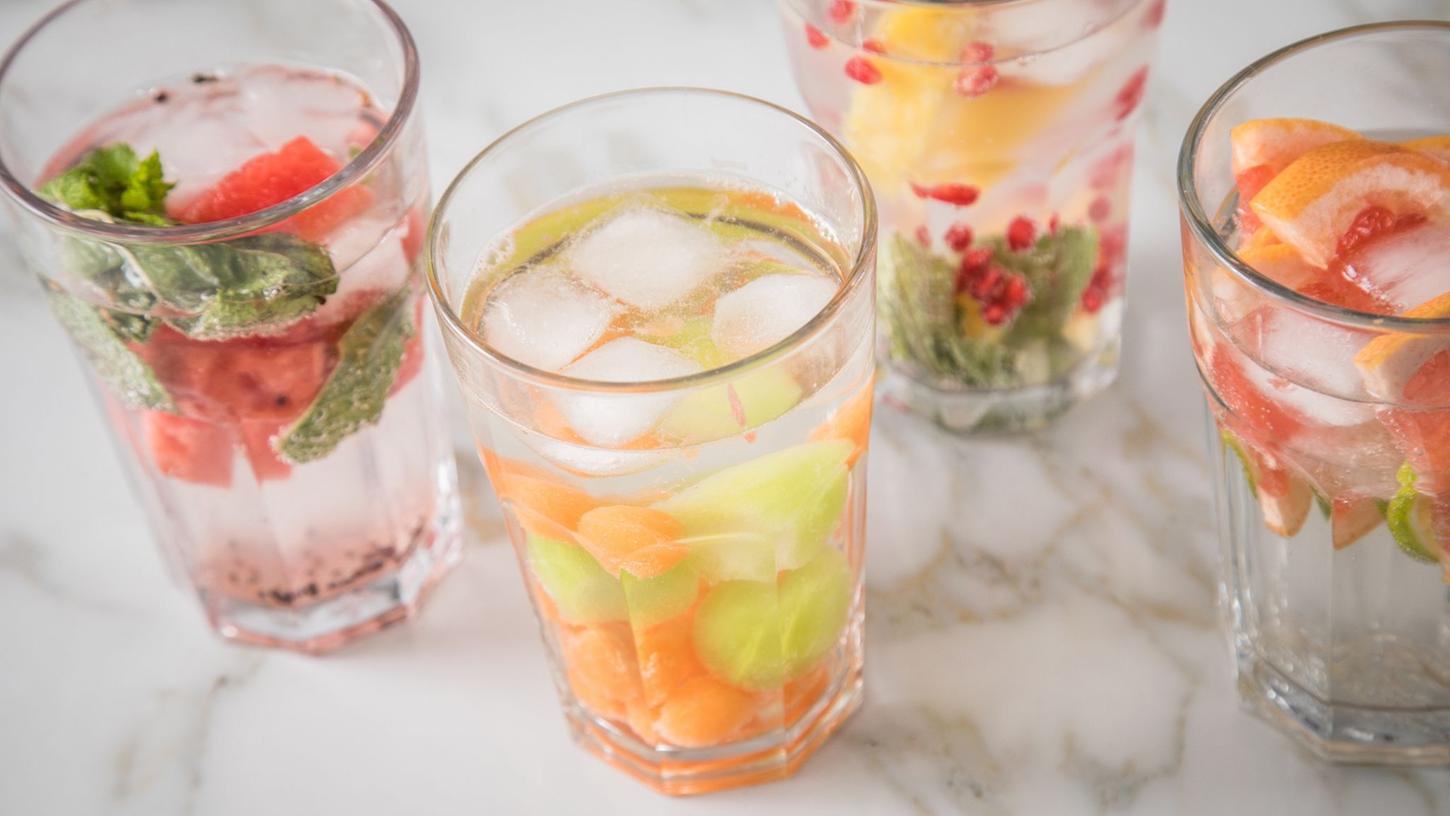 Alles, was hilft, um an heißen Tagen mehr zu trinken: Mit Kräutern, Obst- und Gemüseschnitzen lässt sich Wasser wunderbar aufpeppen.
