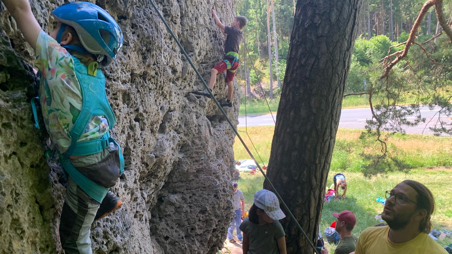 Eingespieltes Team: Der vierjährige Mats klettert die Felswand empor, Vater Philipp sichert ihn ab.
