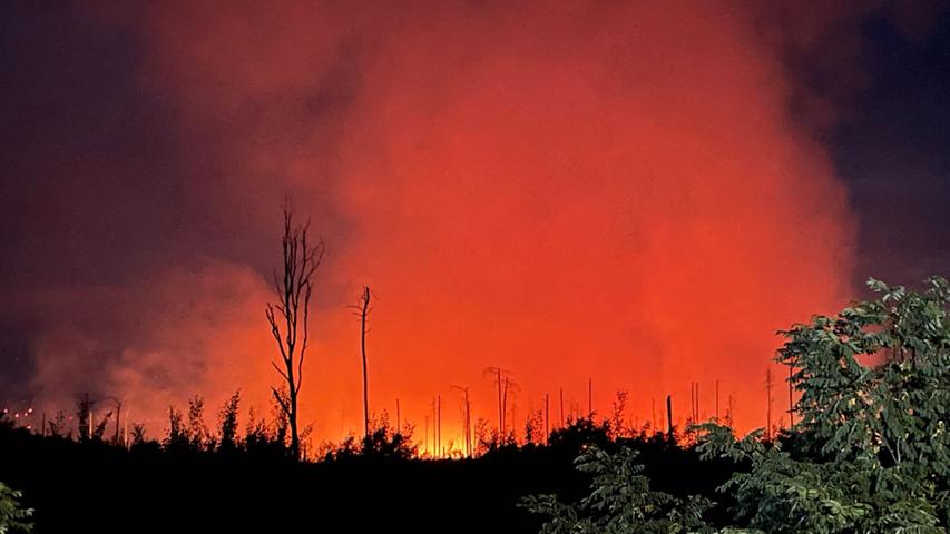 Rot erleuchtet ist der Nachthimmel durch das Feuer eines Waldbrands in der Nähe der brandenburgischen Kleinstadt Treuenbrietzen.