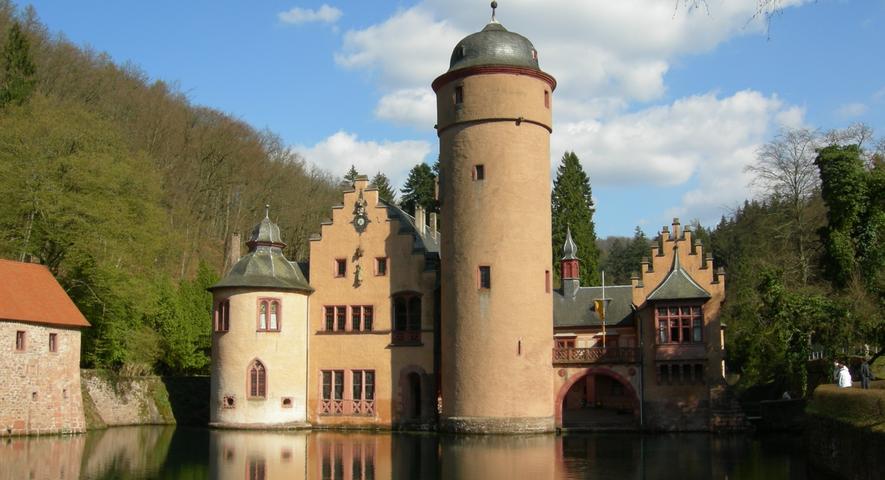 Schloss Mespelbrunn liegt in einem verschwiegenen Spessart-Tal, zwischen Aschaffenburg und Würzburg. Es wurde unter anderem als Drehort des "Wirtshaus im Spessart" mit Liselotte Pulver und Carlos Thompson sowie als Schauplatz für das gleichnamige Theaterstück bekannt. Dank seiner versteckten Lage überstand das Schloss alle Kriege unbeschadet und ist in seiner ursprünglichen Form erhalten geblieben. Seit dem 15. Jahrhundert befindet sich das Wasserschloss in Privatbesitz. Die Eigentümer engagieren sich dafür, das Schloss sowohl als Denkmal zu erhalten und gleichzeitig einer breiten Öffentlichkeit zugänglich zu machen.