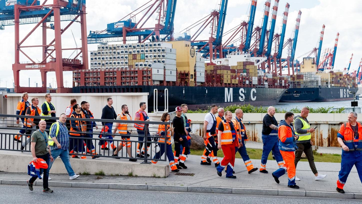 Hafenarbeiter in Hamburg gehen zu einer Streikversammlung.