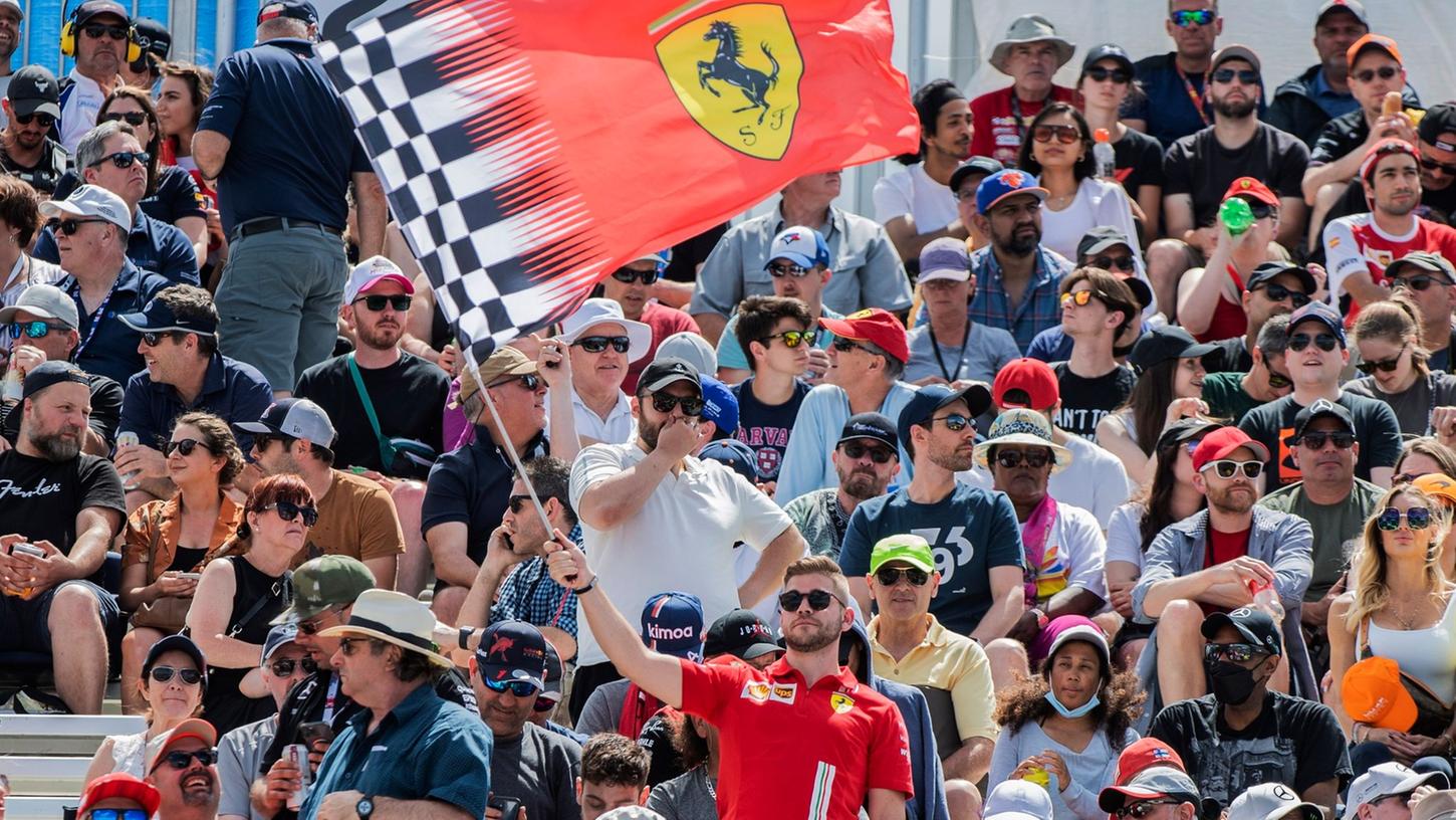 Ein Fan schwenkt eine Ferrari-Flagge auf einer Tribüne. Ein Fan schwenkt eine Ferrari-Flagge auf einer Tribüne.