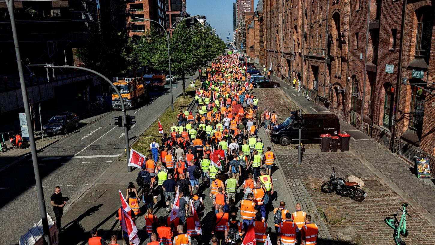 Hafenarbeiter ziehen unter dem Motto "Das Inflationsmonster stoppen" durch die Hamburger Hafencity. Hafenarbeiter ziehen unter dem Motto "Das Inflationsmonster stoppen" durch die Hamburger Hafencity.