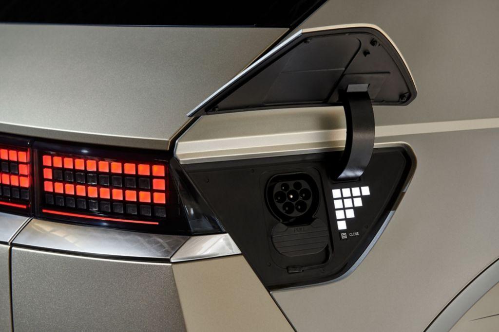 Der Ladeanschluss befindet sich hinten rechts. Leuchten zeigen den Ladestand an.