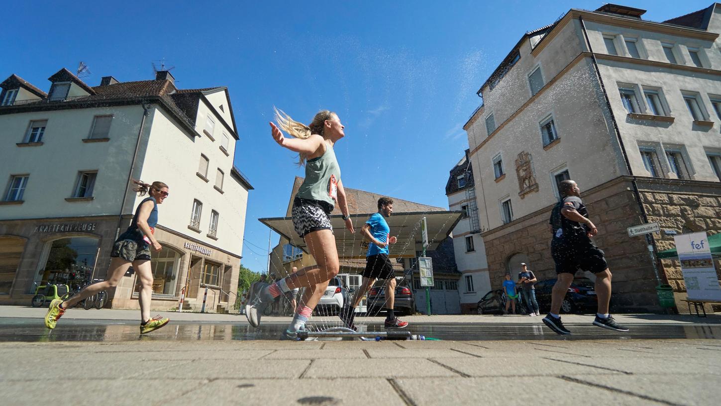 Höchstwillkommene Abkühlung: Unterhalb von Grünen Markt machte ein Rasensprenger die Läuferinnen und Läufer glücklich.