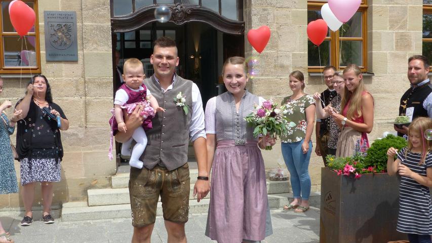 Mit einem großen Hallo wurden die Brautleute Sandra Schuster aus Thundorf und Maximilian Bürner aus Meckenhausen nach der Trauung im Freystädter Rathaus auf dem Marktplatz empfangen. Ihnen zu ehren haben sich die Arbeitskolleginnen der Braut von der katholischen Kindertagesstätte Freystadt, die Studienkolleginnen von der Erzieherinnen-Fachakademie Neuendettelsau, die Mädels der HipHop-Abteilung der DJK Rohr, der Männerstammtisch Meckenhausen, die Clubfreunde Meckenhausen und viele weitere Freunde zu einem Spalier aufgereiht, ließen Seifenblasen und Luftballons in den Himmel schweben und überreichten Geschenke. Die 26-jährige Erzieherin und der 31-jährige Bauleiter lernten sich vor drei Jahren auf der Kirchweih in Pilsach kennen und wohnen inzwischen mit ihrer neun Monate alten Tochter Frieda in Meckenhausen. as
Mit einem großen Hallo wurden die Brautleute Sandra Schuster aus Thundorf und Maximilian Bürner aus Meckenhausen nach der Trauung im Freystädter Rathaus auf dem Marktplatz empfangen. Ihnen zu ehren haben sich die Arbeitskolleginnen der Braut von der katholischen Kindertagesstätte Freystadt, die Studienkolleginnen von der Erzieherinnen-Fachakademie Neuendettelsau, die Mädels der HipHop-Abteilung der DJK Rohr, der Männerstammtisch Meckenhausen, die Clubfreunde Meckenhausen und viele weitere Freunde zu einem Spalier aufgereiht, ließen Seifenblasen und Luftballons in den Himmel schweben und überreichten Geschenke. Die 26-jährige Erzieherin und der 31-jährige Bauleiter lernten sich vor drei Jahren auf der Kirchweih in Pilsach kennen und wohnen inzwischen mit ihrer neun Monate alten Tochter Frieda in Meckenhausen. as