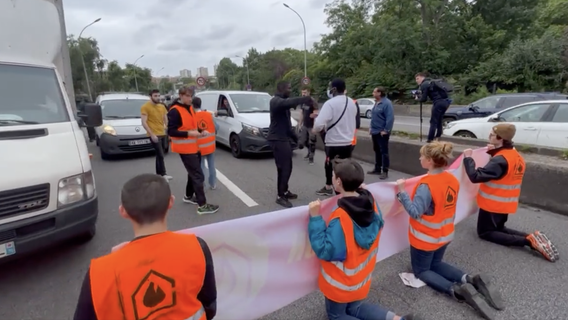 Pariser Polizei reißt festgeklebte Hände von Klima-Aktivisten von der Straße