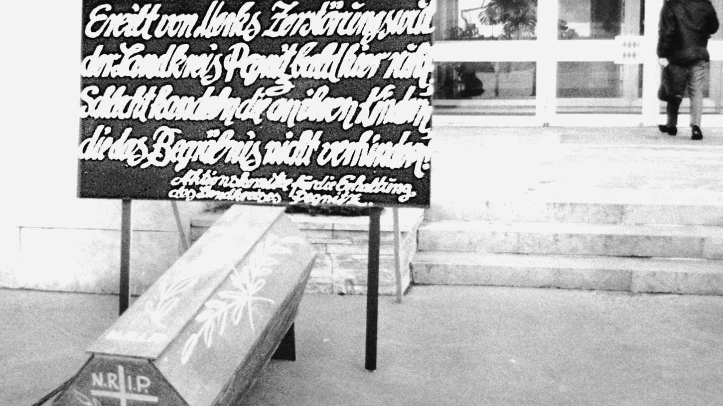 „Ereilt von Merks Zerstörungswut, der Landkreis Pegnitz bald hier ruht. Schlecht handeln an ihren Kindern, die das Begräbnis nicht verhindern“ hatten die Aktivisten auf den Sarg geschrieben, den sie vor dem Pegnitzer Landratsamt platzierten.