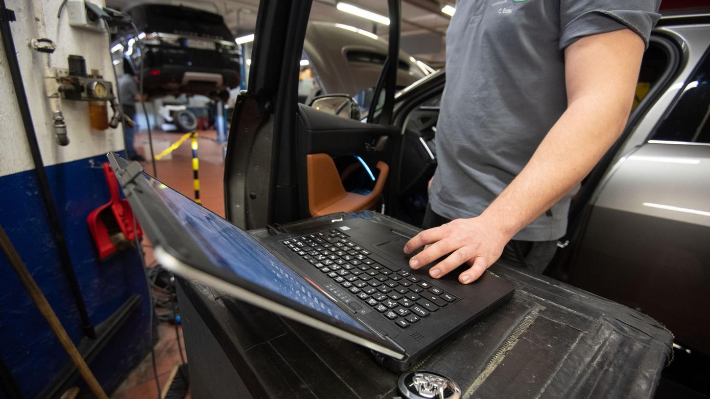 Ein KFZ-Mechaniker wartet in einer Werkstatt einen elektrisch angetriebenen Vorführwagen. Ab dem 3. April ist auch das KFZ-Handwerk in Bayern zu Streiks aufgerufen.