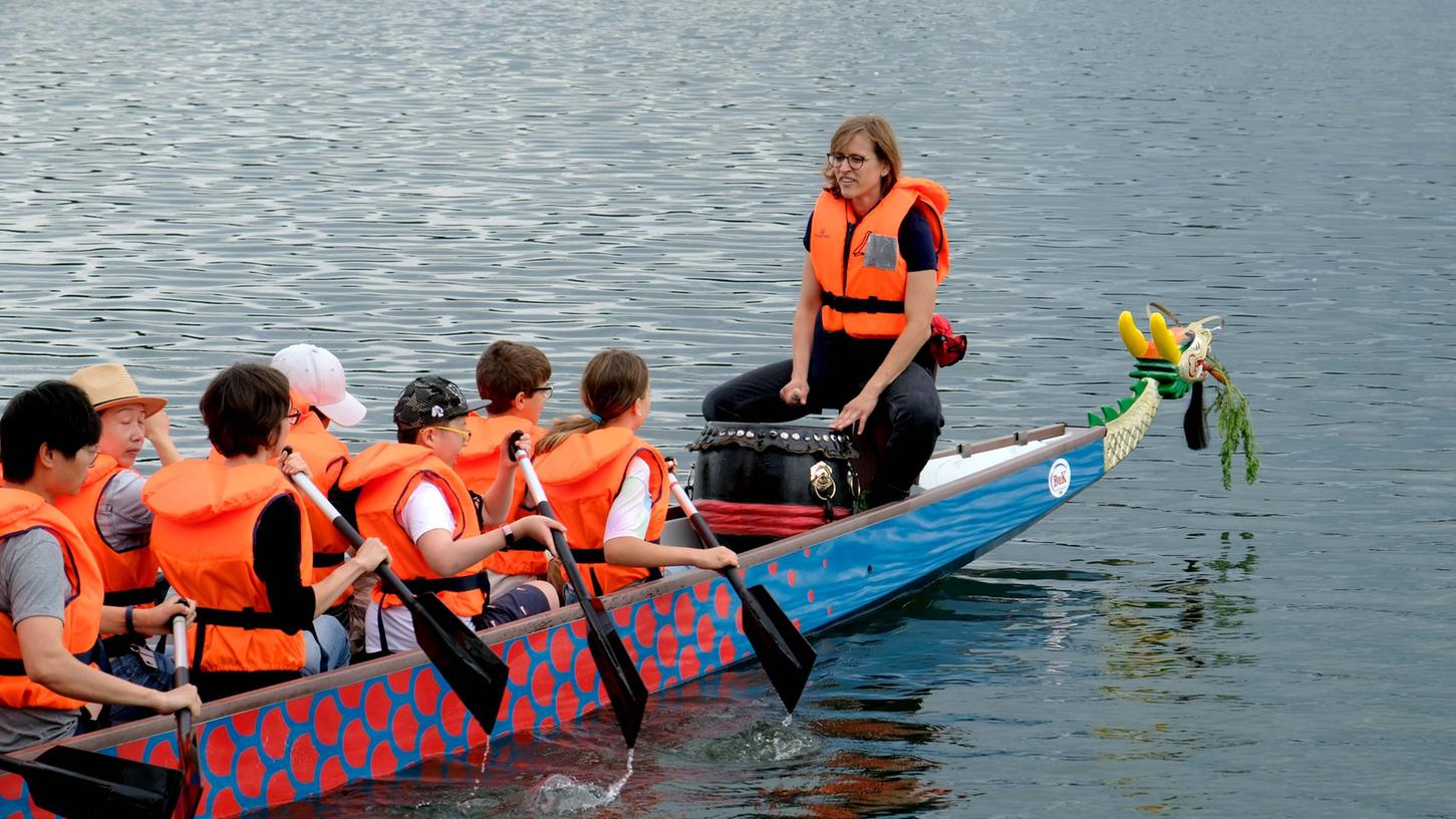 Zugleich! Mit dem frisch getauften Drachenboot schippern die ersten Kinder über den Wöhrder See.